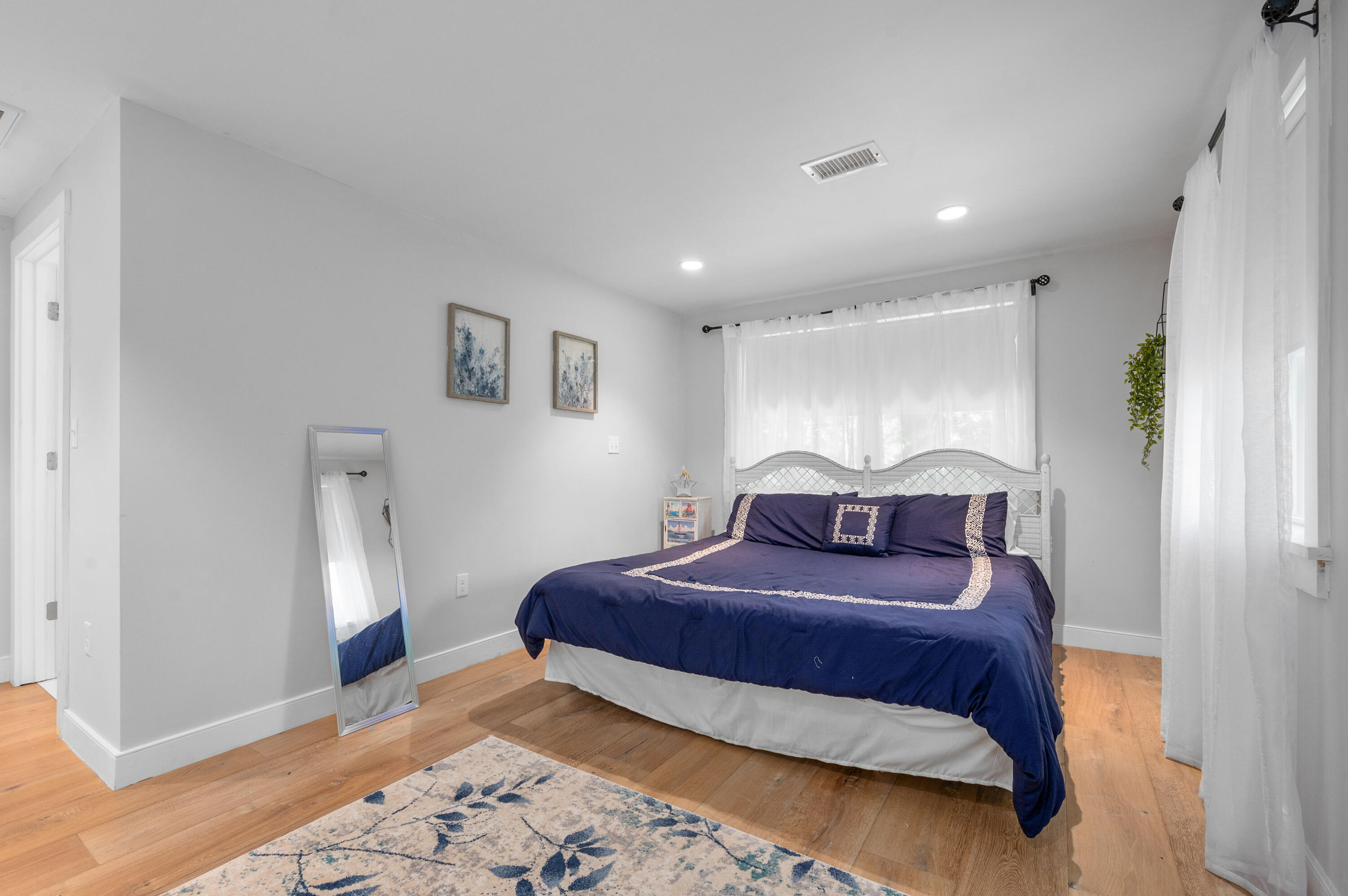 36 Riverside Road Mashpee, MA 02649 - Photo 23 of 48 a bedroom with a large bed and a chandelier