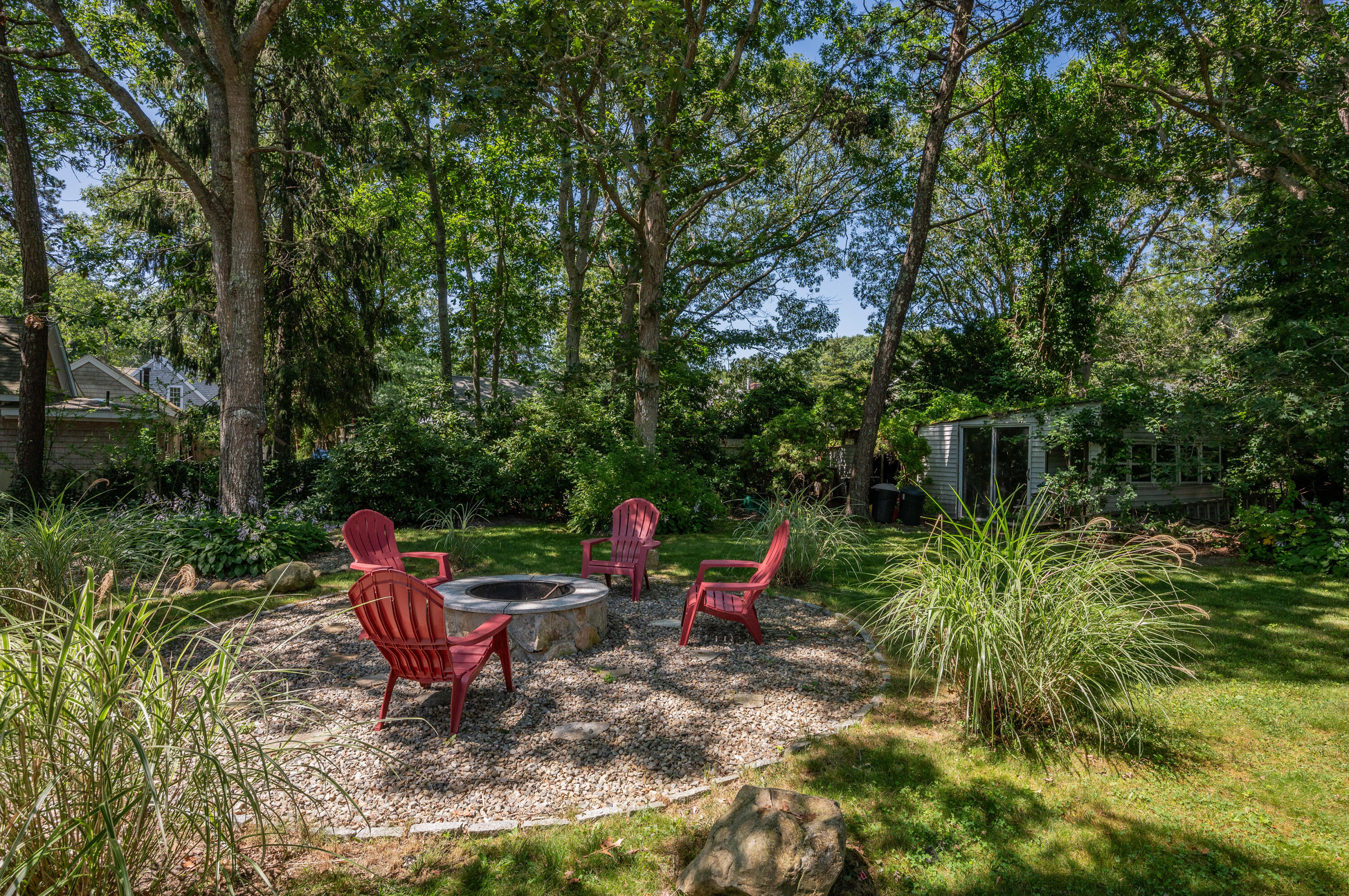 36 Riverside Road Mashpee, MA 02649 - Photo 29 of 48 a view of a wooden chairs and table in a backyard