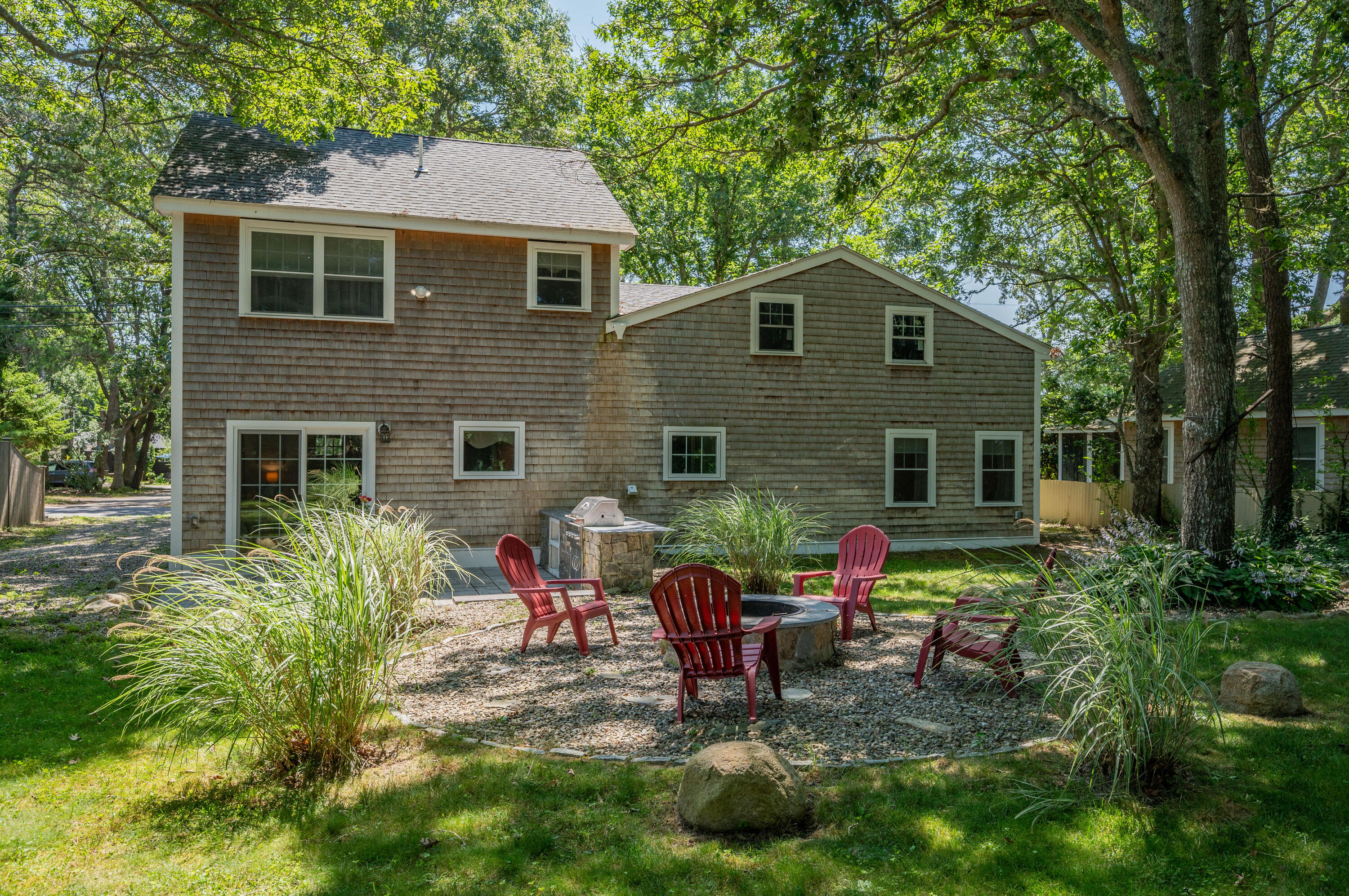 36 Riverside Road Mashpee, MA 02649 - Photo 30 of 48 a backyard of a house with wooden table and chairs