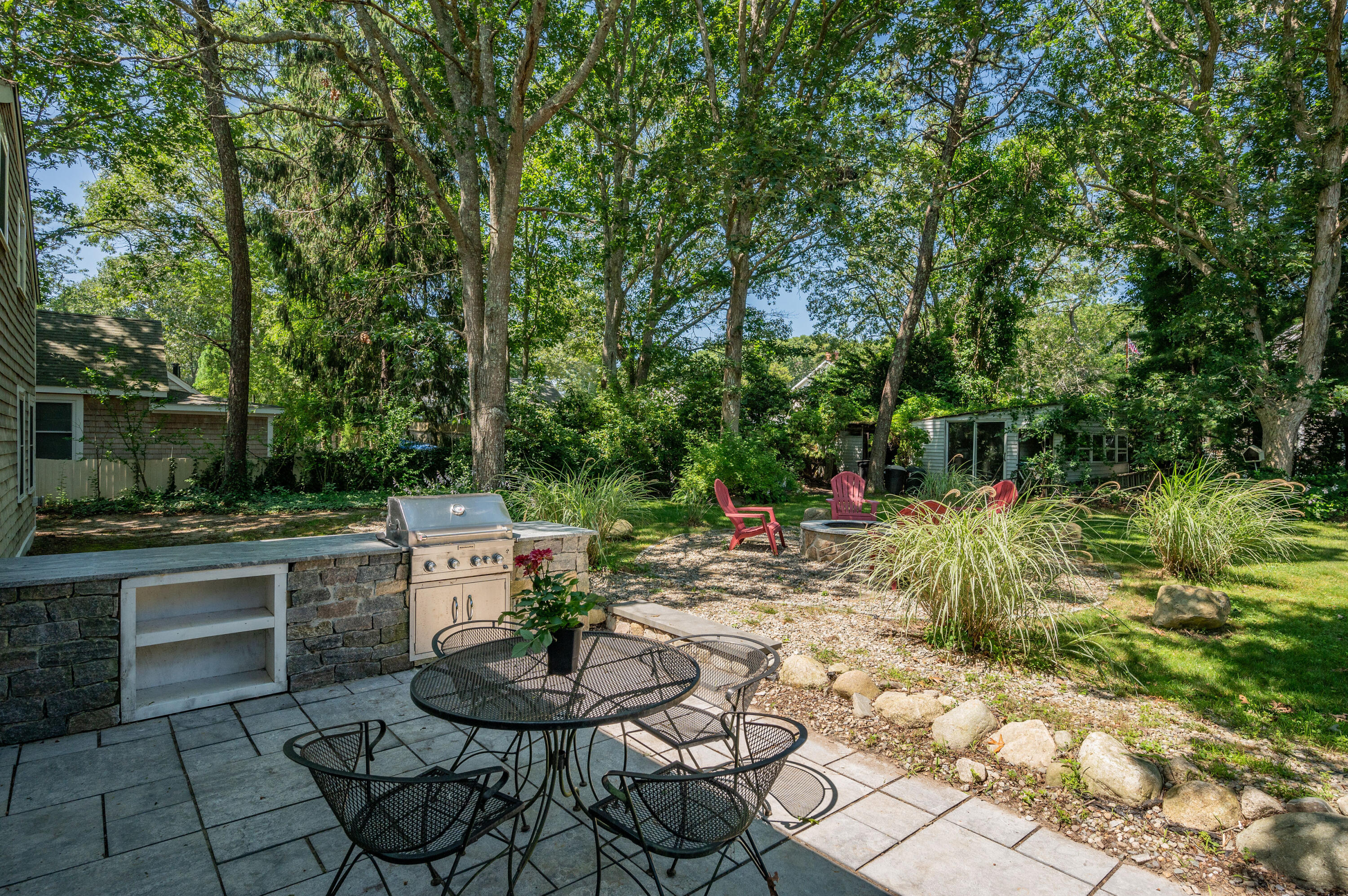 36 Riverside Road Mashpee, MA 02649 - Photo 37 of 48 a backyard of a house with fountain table and chairs