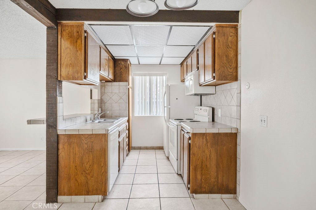 1735 East Washington Street, Unit F14 Colton, CA 92324 - Photo 11 of 26 a kitchen with stainless steel appliances granite countertop a sink and cabinets