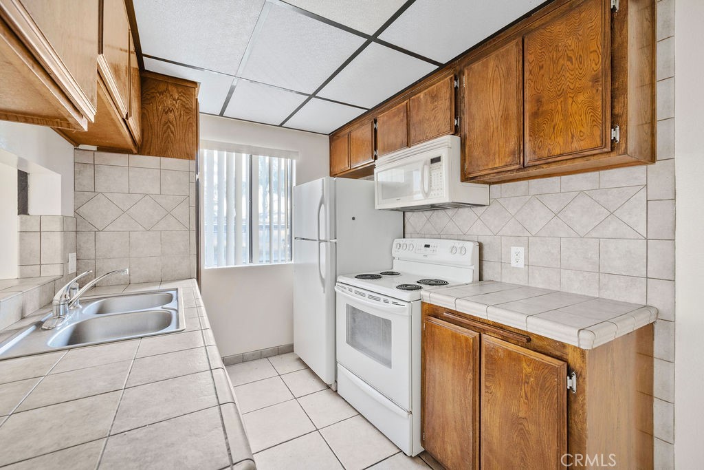 1735 East Washington Street, Unit F14 Colton, CA 92324 - Photo 13 of 26 a kitchen with a sink a stove and cabinets
