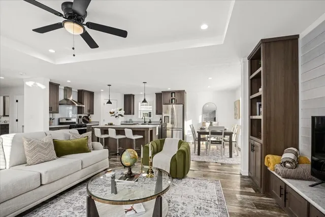 a living room with furniture kitchen view and a chandelier