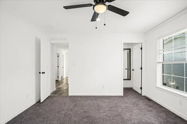 an empty room with fan and windows