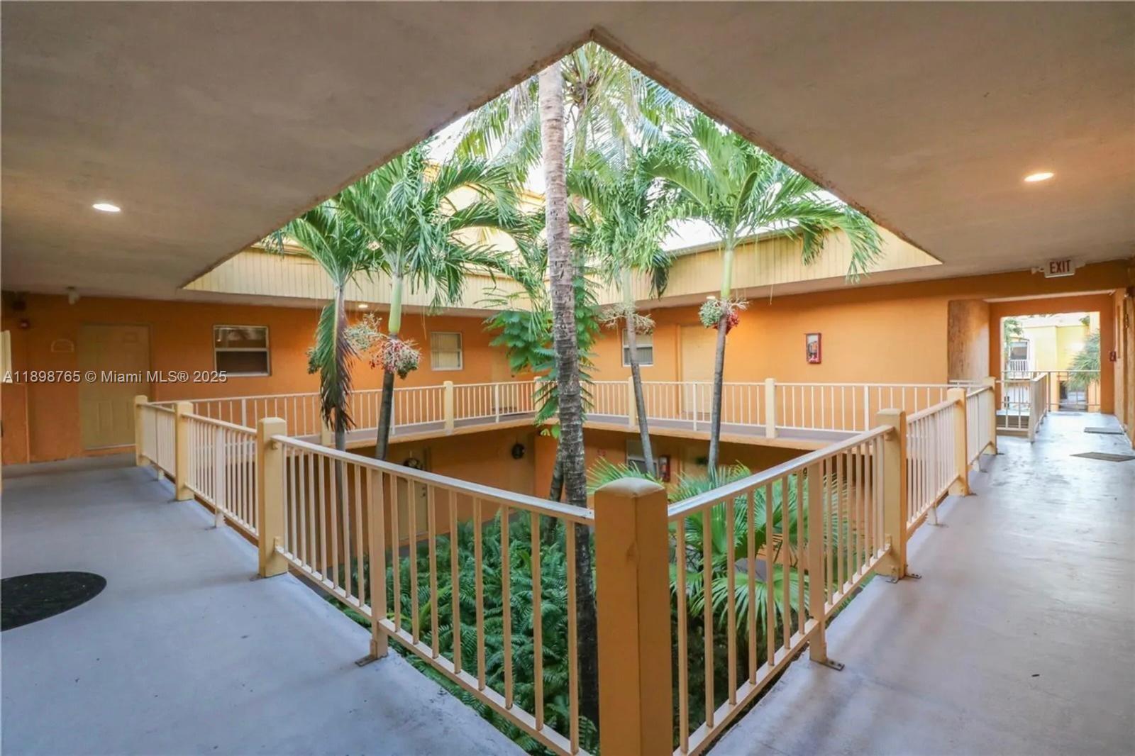 18101 Northwest 68th Avenue, Unit E201 Hialeah, FL 33015 - Photo 12 of 15 a view of staircase with lots of windows and white walls