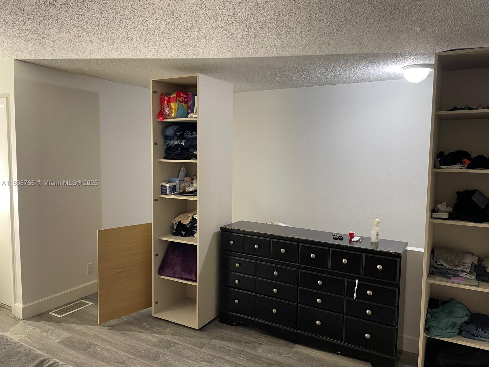 18101 Northwest 68th Avenue, Unit E201 Hialeah, FL 33015 - Photo 10 of 15 walk in closet with clothes and shoes