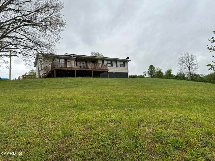 291 Dynatex Road Sunbright, TN 37872 - Photo 2 of 23 a view of a house next to a big yard with large trees