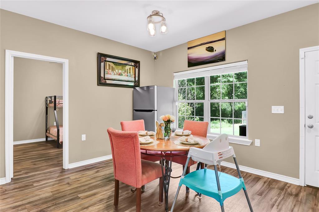 411 Johnson Street Longview, TX 75602 - Photo 13 of 25 a dining room with furniture a window and wooden floor