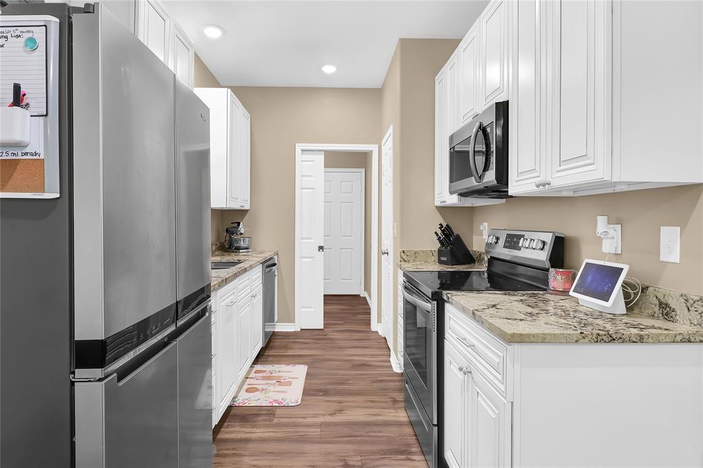 411 Johnson Street Longview, TX 75602 - Photo 16 of 25 a kitchen with granite countertop a sink stove and refrigerator