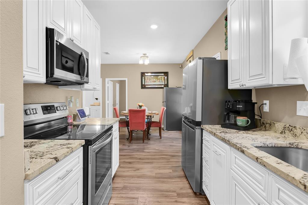 411 Johnson Street Longview, TX 75602 - Photo 18 of 25 a kitchen with stainless steel appliances granite countertop a refrigerator stove microwave and sink