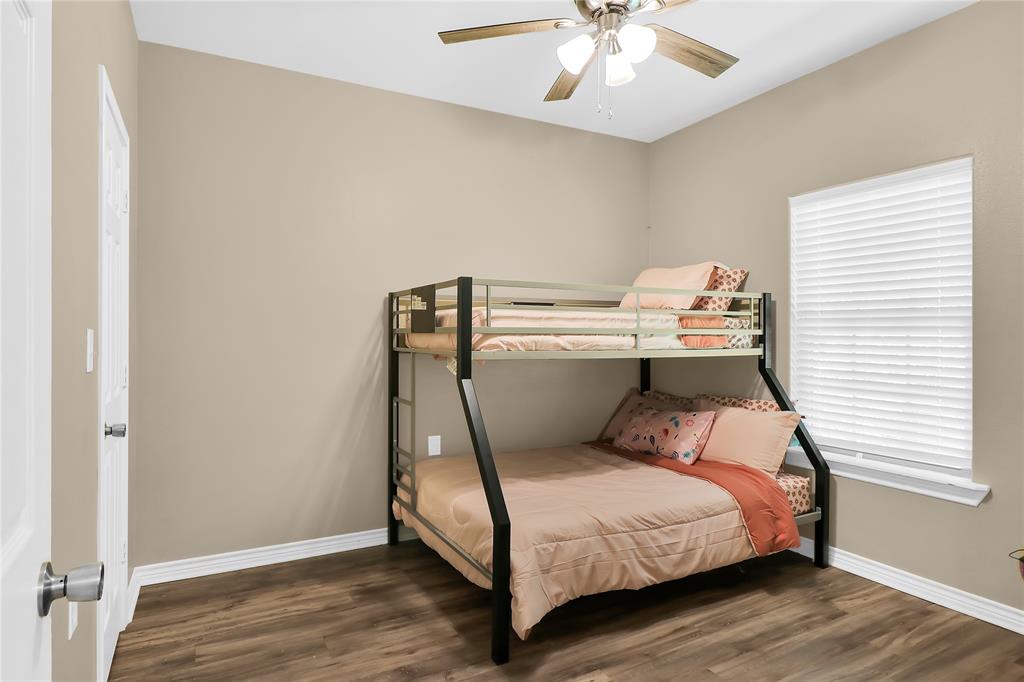 411 Johnson Street Longview, TX 75602 - Photo 21 of 25 a room with a bed and a chandelier