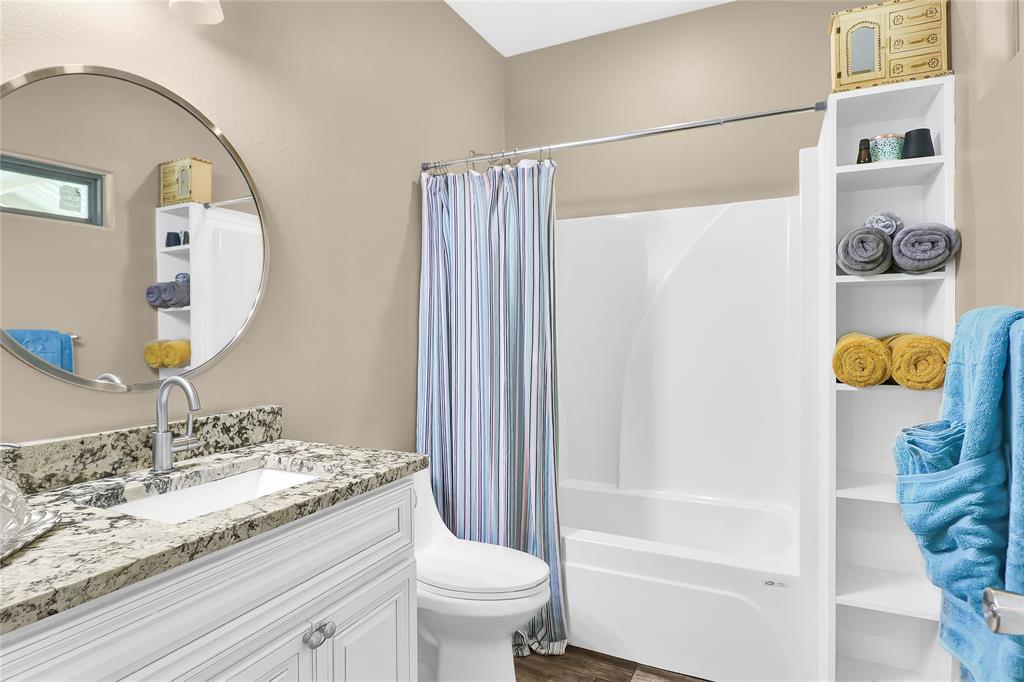 411 Johnson Street Longview, TX 75602 - Photo 23 of 25 a bathroom with a granite countertop sink a toilet and shower