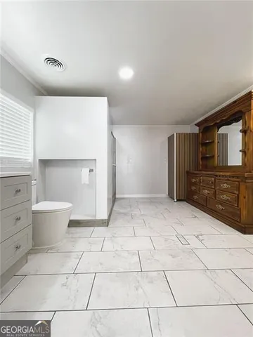 a spacious bathroom with a sink toilet and mirror