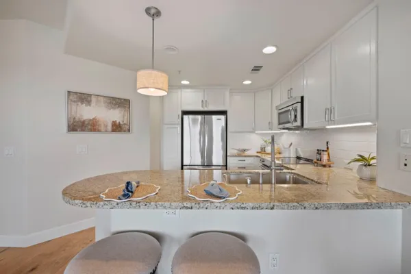 a kitchen with stainless steel appliances granite countertop a refrigerator stove a sink dishwasher and microwave with cabinets