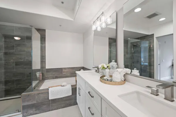 a bathroom with a bathtub shower sink vanity and toilet