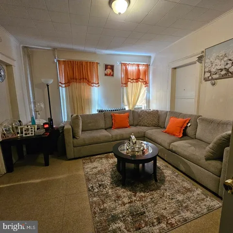 a living room with furniture a rug and a window