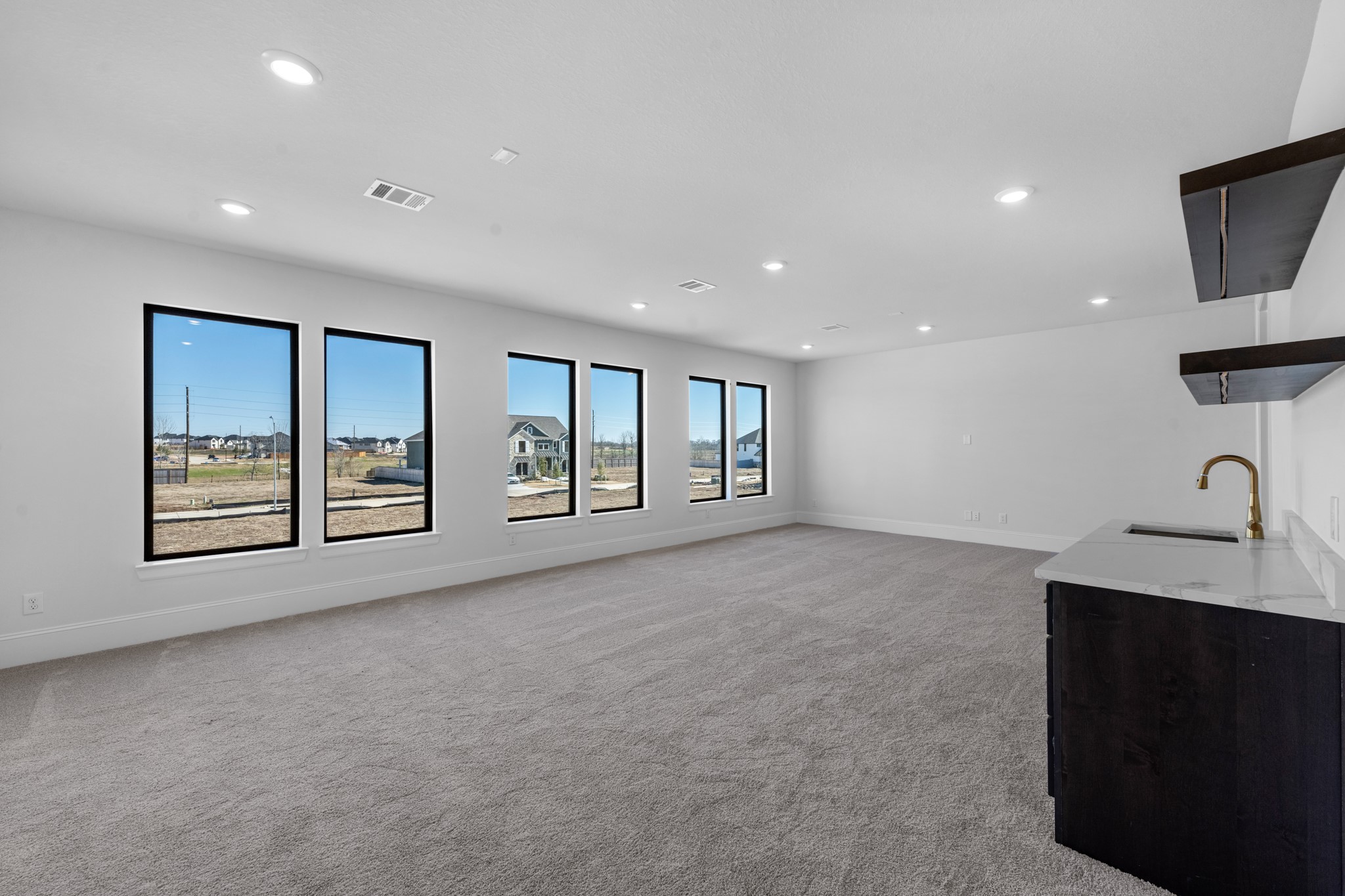 7703 Sparkle Dunn Court Fulshear, TX 77441 - Photo 18 of 20 a view of an empty room with a window and a kitchen