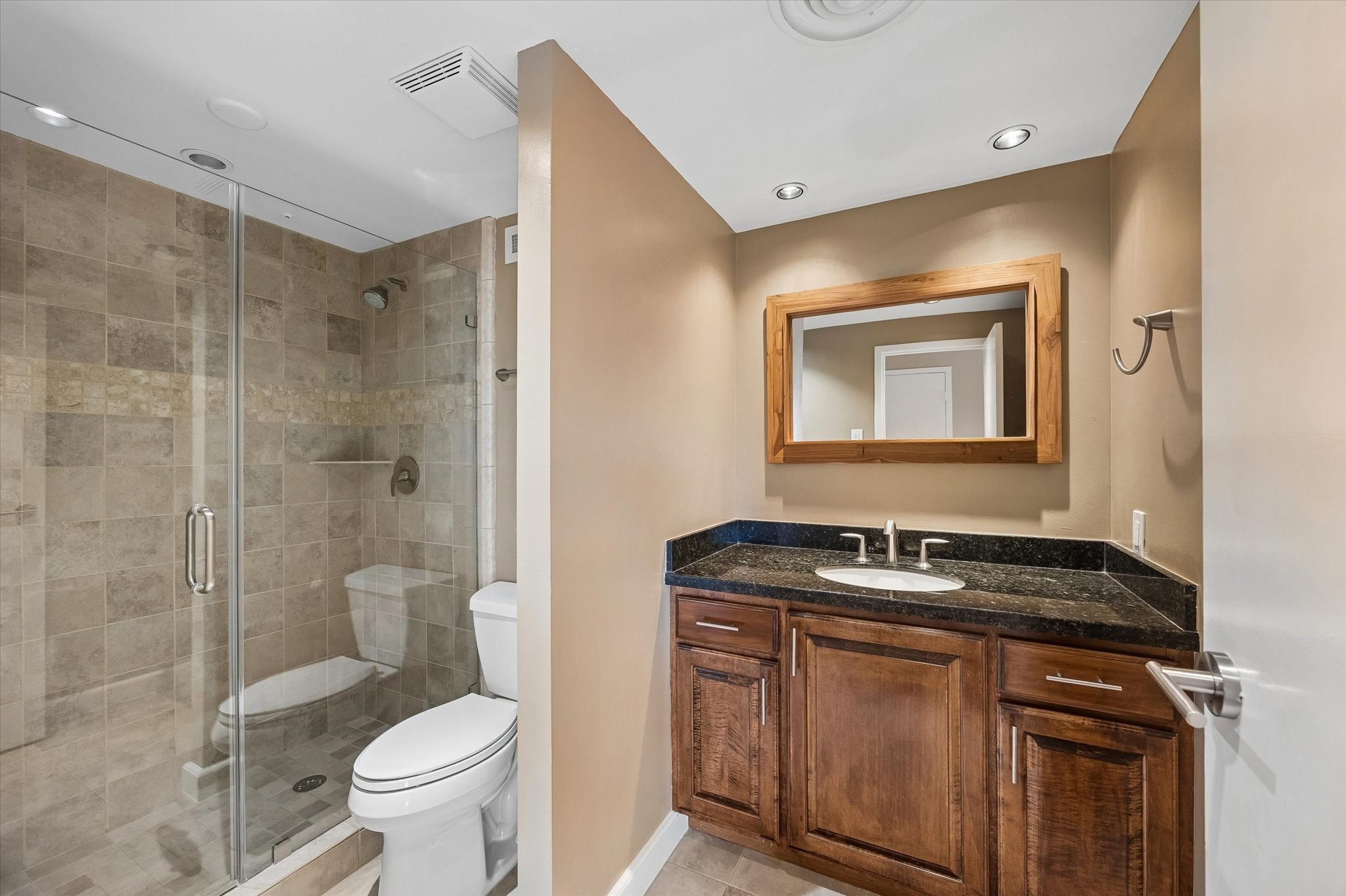 2929 Buffalo Speedway, Unit A513 Houston, TX 77098 - Photo 14 of 24 a bathroom with a granite countertop sink toilet mirror and shower