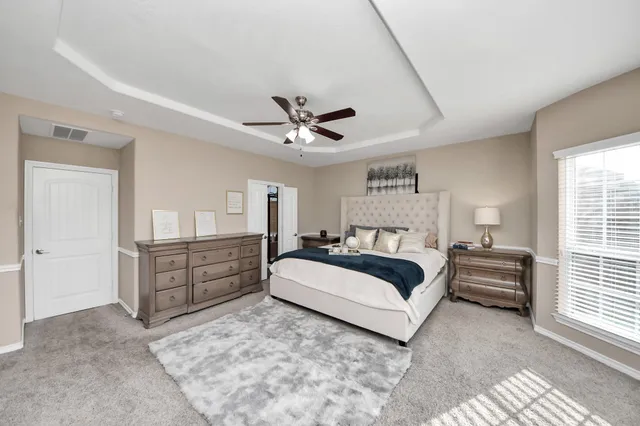 a bedroom with a large bed and a ceiling fan