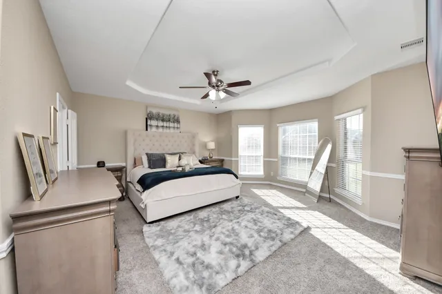 a spacious bedroom with a bed a couch and a large window with the outer view