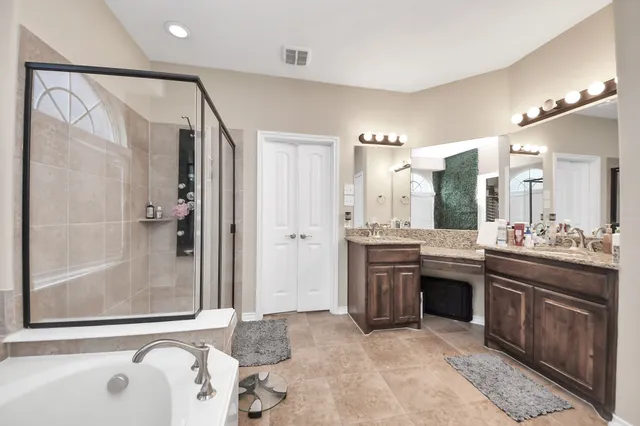 a bathroom with a tub sink shower and mirror