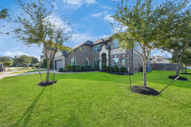 a house with green field in front of it