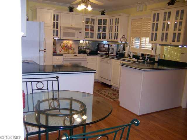 423 Kyle Road Winston-Salem, NC 27104 - Photo 2 of 16 Kitchen. Beautiful Marsh cabinets with glass doors and under counter lighting....Easy roll out shelving in cabinets and pantry too,! Corner lazy Susans.. Solid surface counter tops with beautiful hardwood floors and moldings