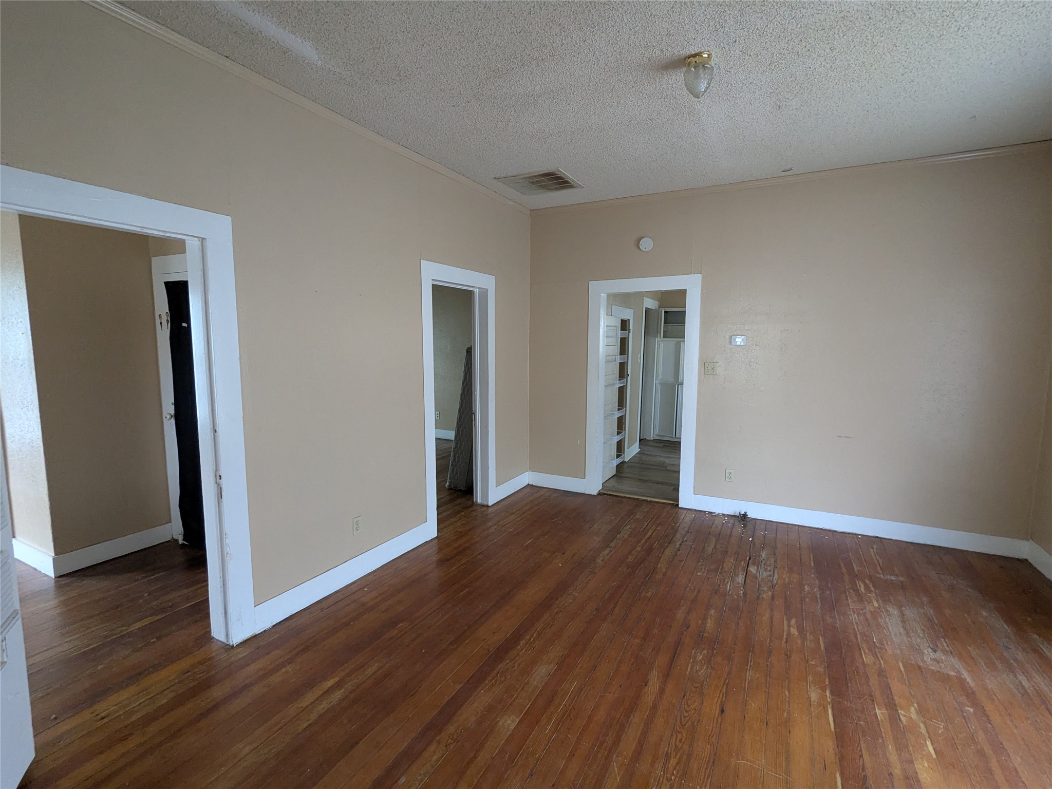 301 Park Street Taylor, TX 76574 - Photo 3 of 13 an empty room with wooden floor and closet