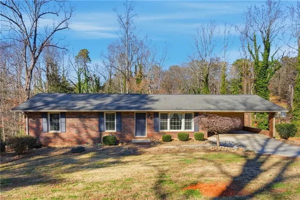 a view of a house with backyard and tree