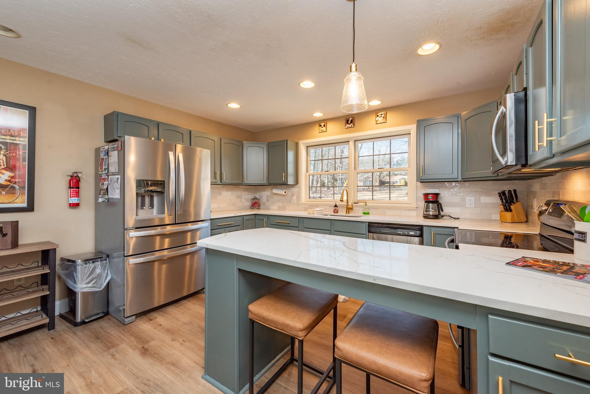 2828 Glendale Road Swanton, MD 21561 - Photo 7 of 78 a kitchen with stainless steel appliances granite countertop a refrigerator a sink dishwasher a stove and white countertops with wooden floor