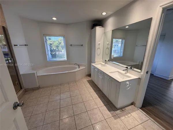 a bathroom with a bathtub a sink and a mirror