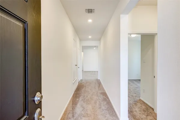 a view of a hallway with wooden floor