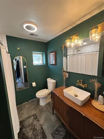 a bathroom with a toilet a sink and mirror