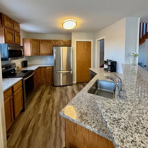 a kitchen with stainless steel appliances granite countertop a sink stove microwave and refrigerator