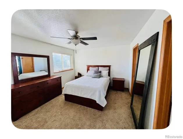 a bedroom with a bed window and a flat screen tv