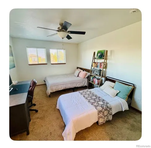 a bedroom with two beds and a desk