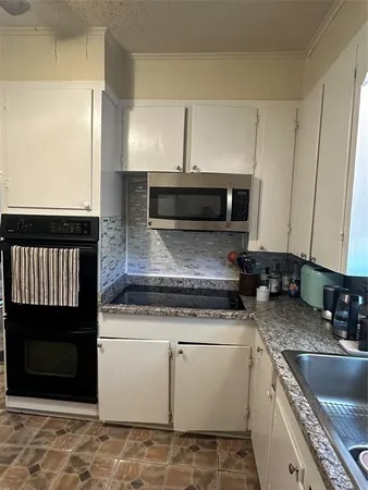 a kitchen with a sink stove and microwave