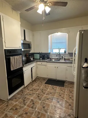 a kitchen with a sink a refrigerator and cabinets