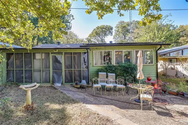 a backyard of a house with table and chairs