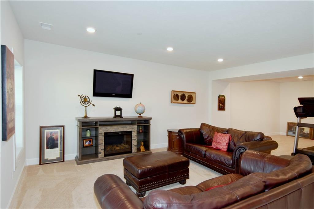 4103 Spruce Road Gibsonia, PA 15044 - Photo 21 of 25 a living room with furniture a fireplace and a flat screen tv