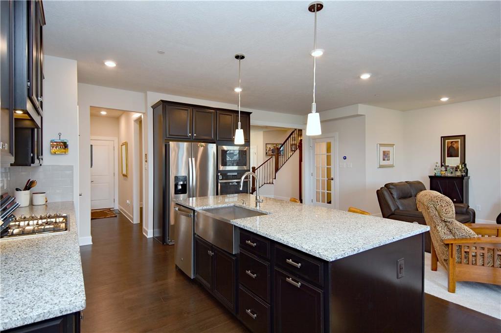 4103 Spruce Road Gibsonia, PA 15044 - Photo 6 of 25 a kitchen with granite countertop a table chairs refrigerator and microwave