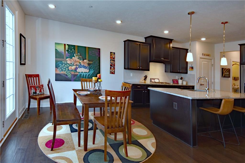4103 Spruce Road Gibsonia, PA 15044 - Photo 8 of 25 a kitchen with stainless steel appliances kitchen island granite countertop a dining table chairs refrigerator and microwave
