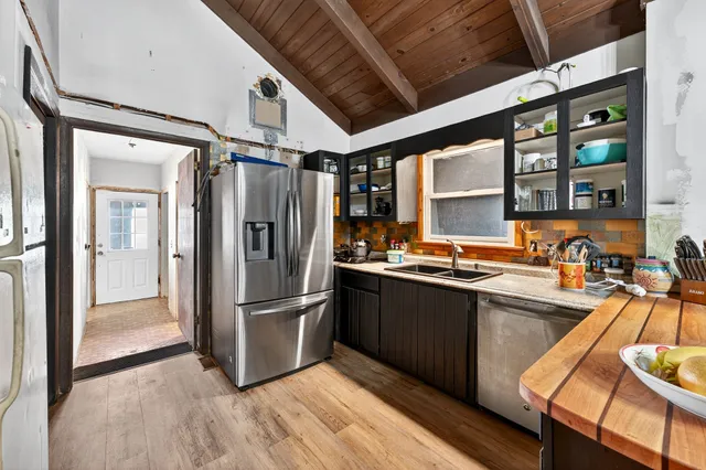 a kitchen with stainless steel appliances granite countertop a refrigerator and a sink