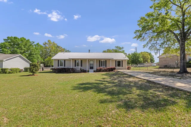 a front view of a house with yard and green space