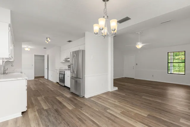 a view of a kitchen with a sink dishwasher a refrigerator and a stove top oven