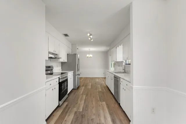a large kitchen with a stove top oven sink and cabinets