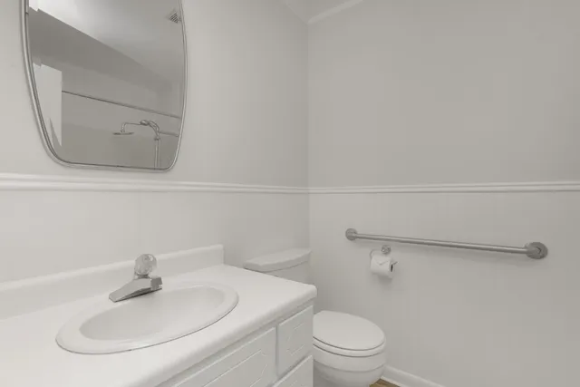 a bathroom with a sink a toilet and a mirror