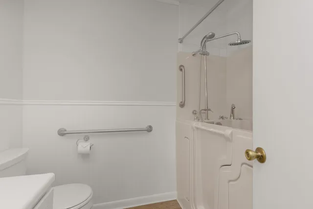 a bathroom with a shower a toilet and sink