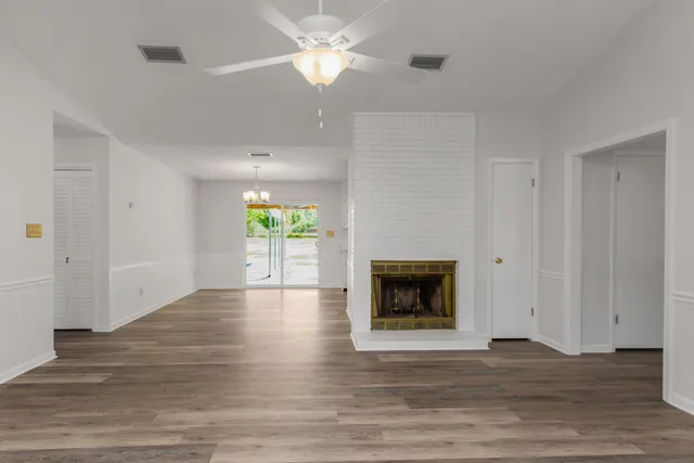 a view of an empty room with a fireplace and a window