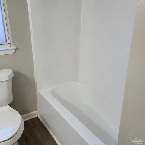 a white toilet sitting next to a bath tub
